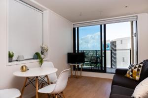 奥克兰Brand New Auckland Apartment的客厅配有沙发和桌子