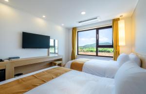 西归浦市锡拉酒店的酒店客房设有两张床和大窗户。