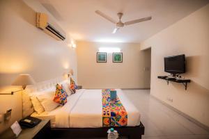 新德里沙克德阿努坦法布酒店的一间带大床和电视的卧室