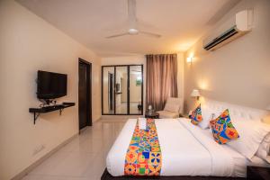 新德里沙克德阿努坦法布酒店的一间酒店客房,配有一张床和一台电视