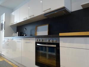 莱比锡Gorki42的厨房配有白色橱柜和炉灶烤箱。
