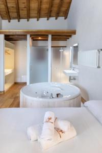 擞莫Somo Garden Villas的带浴缸和桌子毛巾的浴室