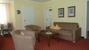 维林根苏纳罕度假别墅的客厅配有沙发、两把椅子和一张桌子