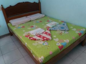 苏里高Eco Pension的一张带绿毯的床铺,有心和鲜花
