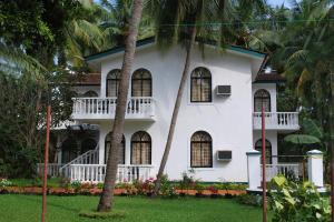 坎多林Albuquerque BetterHomes, Goa的两棵棕榈树前的白色房子
