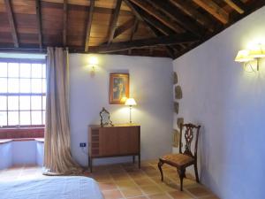 Valle de Guerra海赛达德瓦丽螺斯肯雅乡村民宿的一间卧室配有一张床和一把椅子
