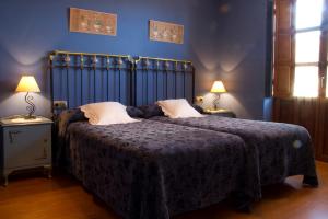 Murias de Rechivaldo韦莱塔乡村酒店的一间卧室配有一张带蓝色墙壁的大床