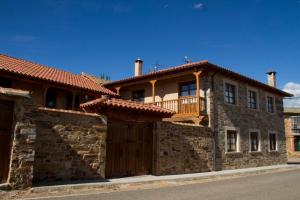Murias de Rechivaldo韦莱塔乡村酒店的石头房子,设有木门和阳台
