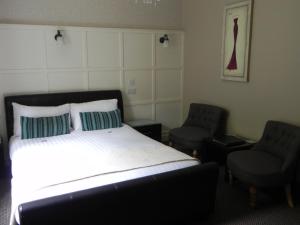 斯莱戈Pearse Lodge的一间卧室配有一张床和两把椅子