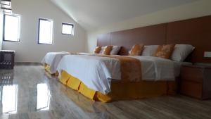 金马仑高原郁金香公寓式酒店的一间卧室配有一张带白色和橙色床单的大床