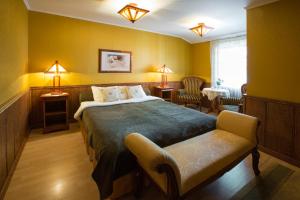 派尔努伊登别墅酒店的一间卧室配有一张床、椅子和灯具