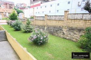 桑坦德Enjoy Santander的花在草地上,围墙旁的花园