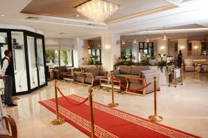 突尼斯Marigold Hotel的站在大堂的一个人,铺有红地毯