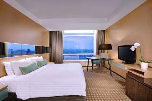 巨港The Alts Hotel的酒店客房设有一张大床和一台电视。