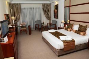 突尼斯Marigold Hotel的酒店客房设有一张大床和一台电视。