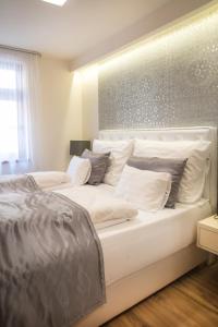 杰尔Főtér Rezidencia 2的卧室内的白色床和白色枕头