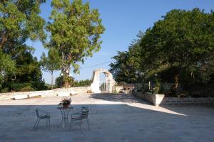 奥斯图尼Casa del Sud的庭院配有桌椅和树木