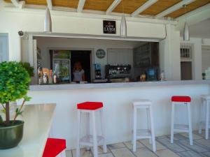 圣安娜纳克索斯Naxos Hostel的餐厅内带红色凳子的酒吧