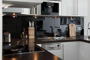 柏林鲁克斯依斯公寓的厨房配有白色橱柜和黑色台面