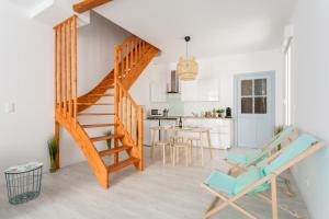 贝济耶RELAXING 95m² DUPLEX APPARTEMENT 3 Chambres的客厅里设有椅子和厨房,楼梯是客厅里的一个楼梯