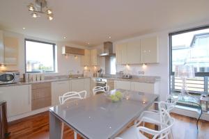 牛津Oxfordshire Living - The Monroe Apartment - Oxford的厨房配有桌子和一些白色的椅子