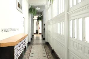 利马1900旅馆的走廊上设有白色的墙壁和窗户,地毯