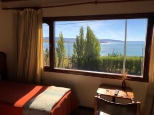 埃尔卡拉法特考伊爱肯酒店的一间卧室设有大窗户,享有水景