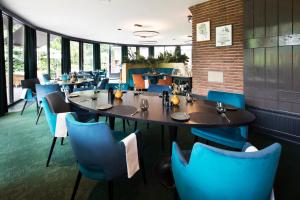 蒂尔堡杜博纳尔旅馆的一间配备有桌子和蓝色椅子的用餐室