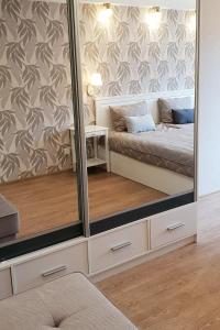 克拉斯拉瓦Kraslava 2 Bedroom Lux Apartments的一张床位和一张桌子,镜子里