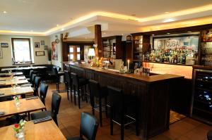 毛尔布龙Zum Scheffelhof的餐厅内的酒吧配有桌椅