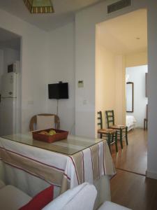 塞维利亚Apartamento céntrico Plaza del Salvador的厨房以及带桌椅的起居室。
