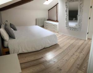 加尔达湖滨Appartamento i Sentieri 23的卧室配有白色的床和镜子