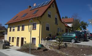 拜罗伊特Ferienwohnung Wagner Bayreuth的黄色的房子,屋顶上设有太阳能电池板
