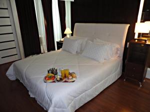 阿拉萨图巴佩金宫酒店的一张白色的床,上面有水果盘
