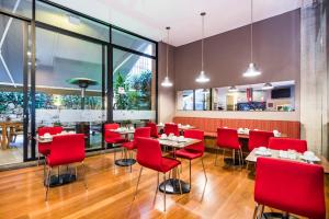 波哥大84 DC Bogotá的一间带红色椅子和桌子的餐厅