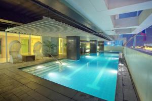 伊洛伊洛Injap Tower Hotel的夜间酒店游泳池