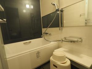 东京羽田旅馆的带浴缸、卫生间和镜子的浴室