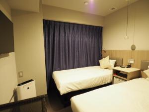 东京羽田旅馆的酒店客房设有两张床和窗户。