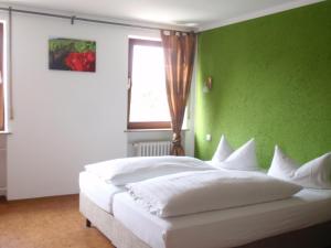 SandWeinhotel Goger的一间卧室配有一张白色的床和绿色的墙壁