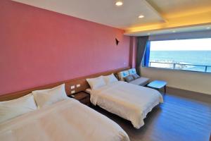 花莲市贰馆海景民宿的酒店客房设有两张床和大窗户。