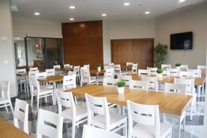 阿尔苏阿HOTEL ARZÚA的一间会议室,配有桌子和白色椅子