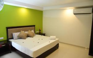 ChottanikaraTemple Plaza Kochi的一间卧室设有一张带绿色墙壁的大床