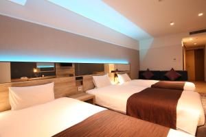 札幌札幌坤特萨酒店的酒店客房,设有两张床和一张沙发