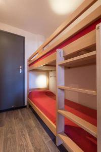 莱德萨阿尔卑斯Vacanceole - Résidence Andromede的一间卧室配有两张双层床和一张红色的床