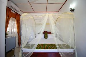 本托塔本托特民宿的一间卧室配有一张带天蓬的床