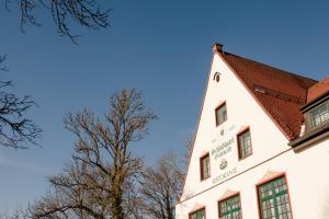 格林瓦尔德格伦瓦尔德城堡酒店的白色的建筑,有红色的屋顶和一棵树