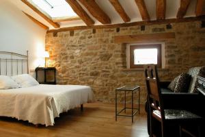 MurugarrenCasa Baquedano的一间卧室设有一张床和石墙