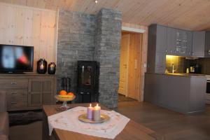 GolsfjelletBergestua - 4 bedroom cabin的客厅设有壁炉和带蜡烛的桌子。