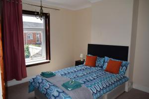 林肯Kavig House的一间卧室配有蓝色和橙色枕头的床