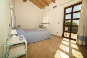 阿列恩图Villamarina Garden Relais的一间卧室配有一张床、一张桌子和一个窗户。